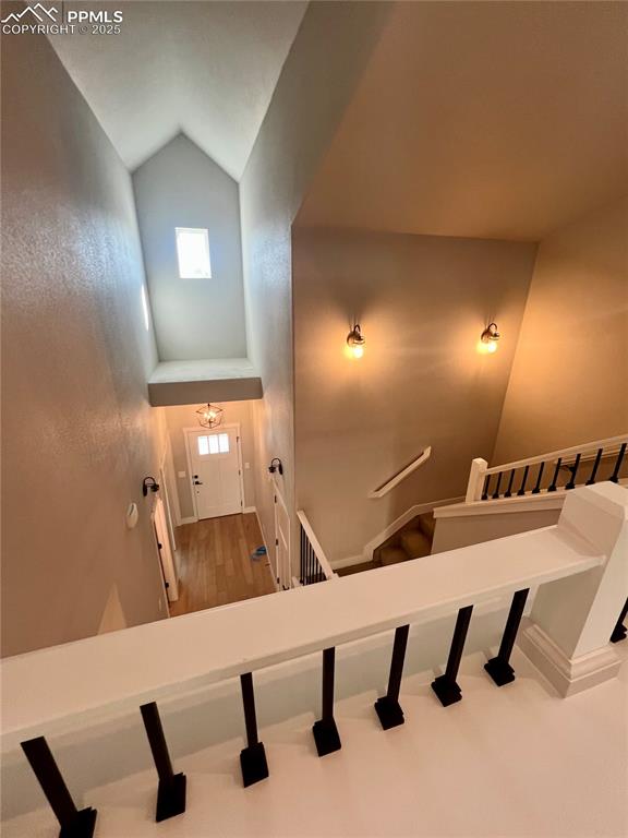 Image 13 of 19: Stairway with high vaulted ceiling and wood finished floors