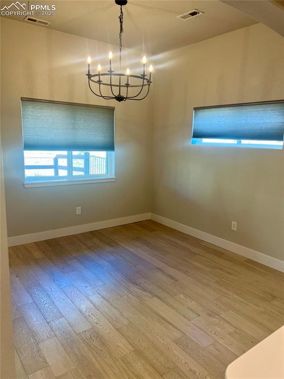 Image 17 of 19: Empty room featuring light wood finished floors and a chandelier