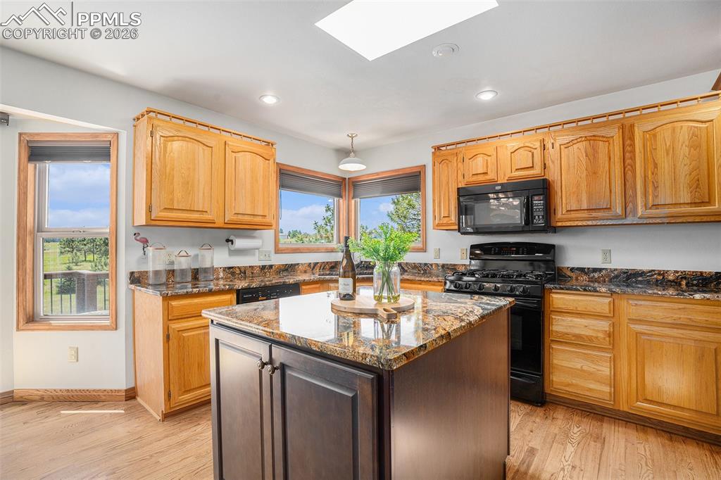Image 11 of 49: Sun-drenched chef’s kitchen features granite countertops, a spacious island