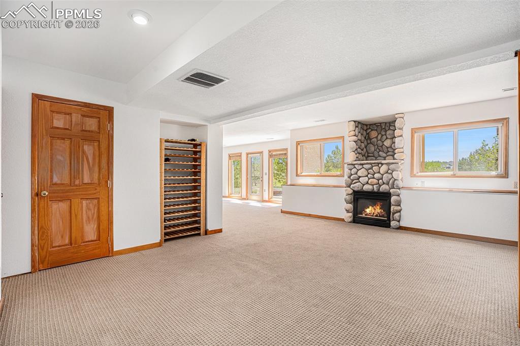 Image 27 of 49: The fully finished walkout basement offers a fireplace, full bath, and flex