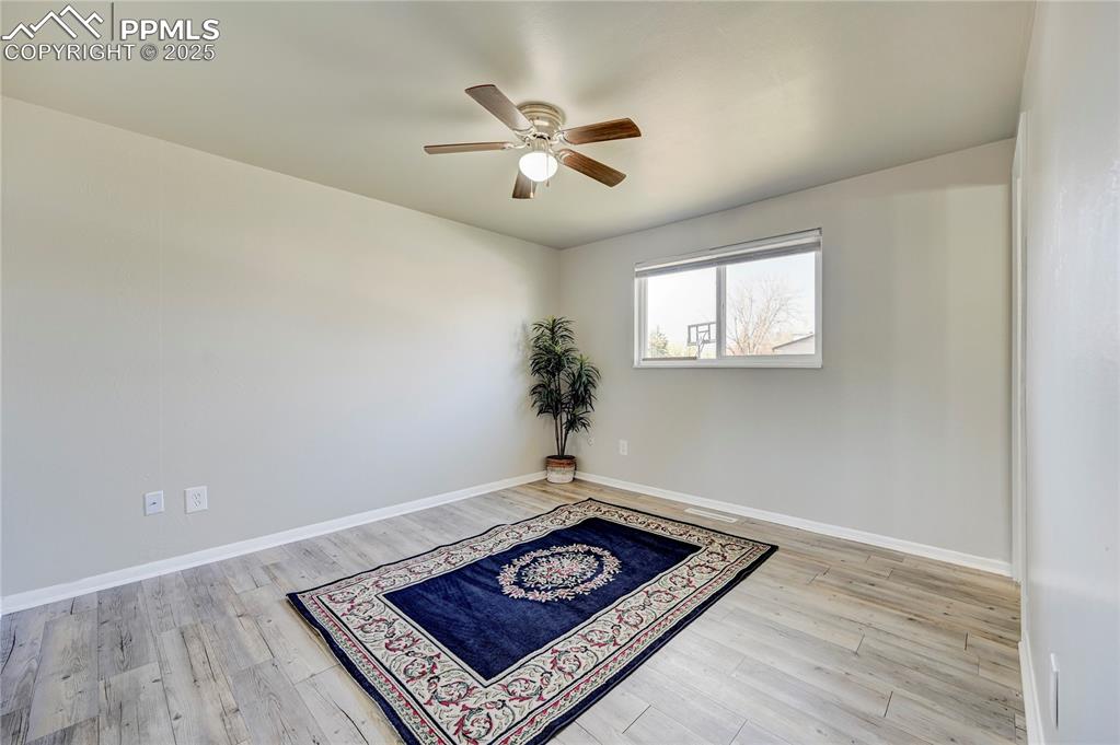 Image 16 of 26: Spare room with baseboards, a ceiling fan, and wood finished floors