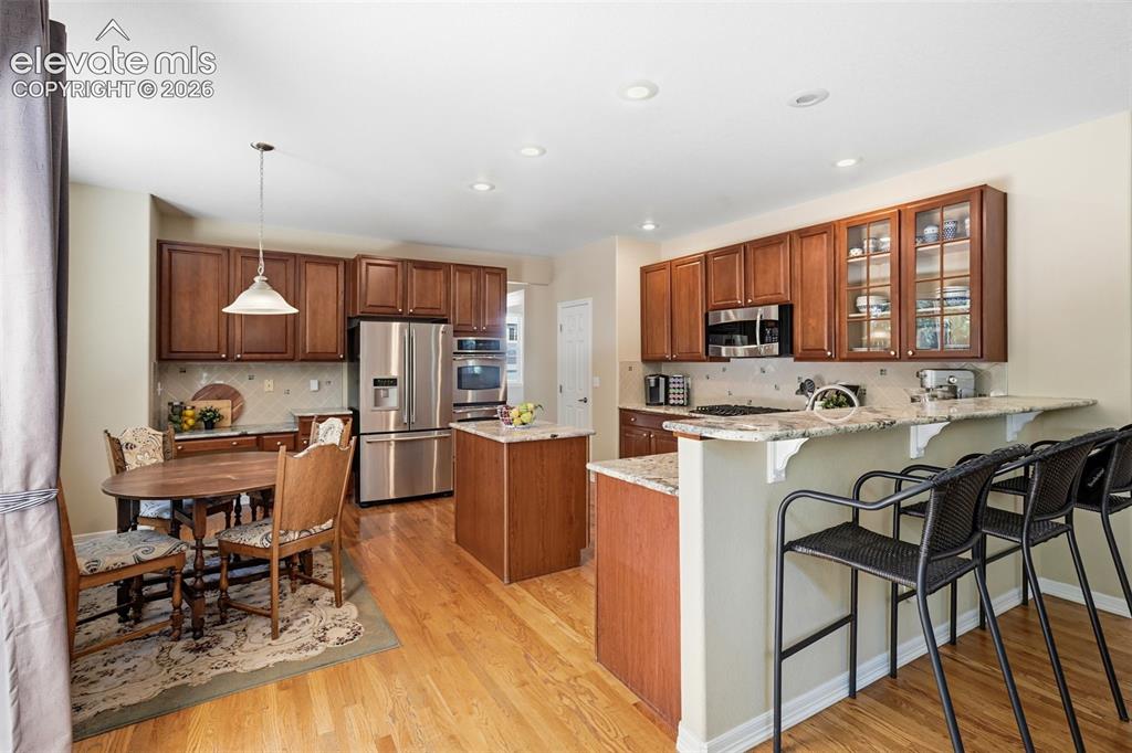 Image 13 of 50: The beautiful kitchen offers counter top eating, an island and breakfast no