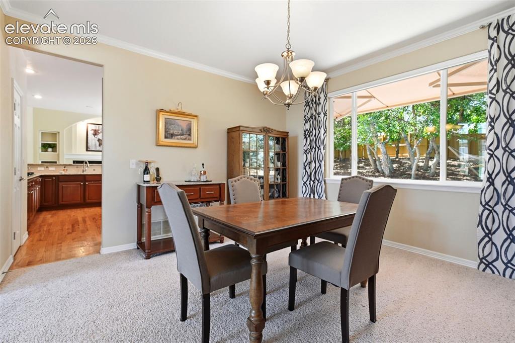 Image 19 of 50: Dining room offers a view of the peaceful backyard
