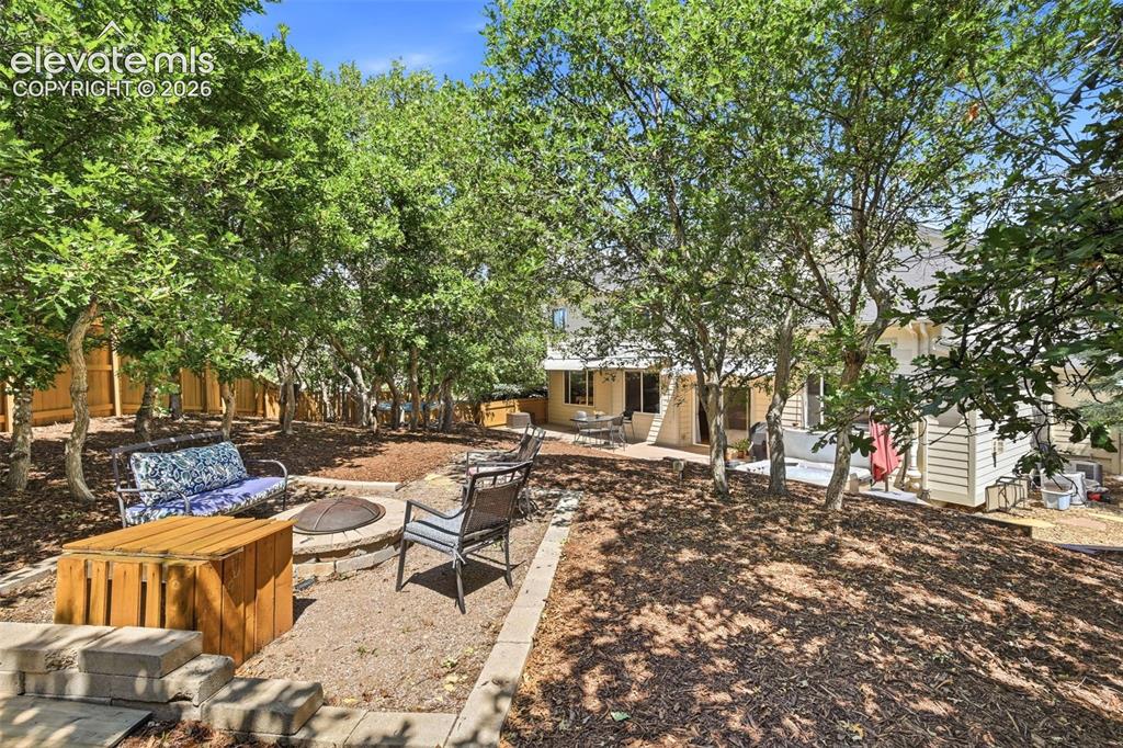Image 23 of 50: Enjoy relaxing next to the fire pit in the large, fenced backyard!