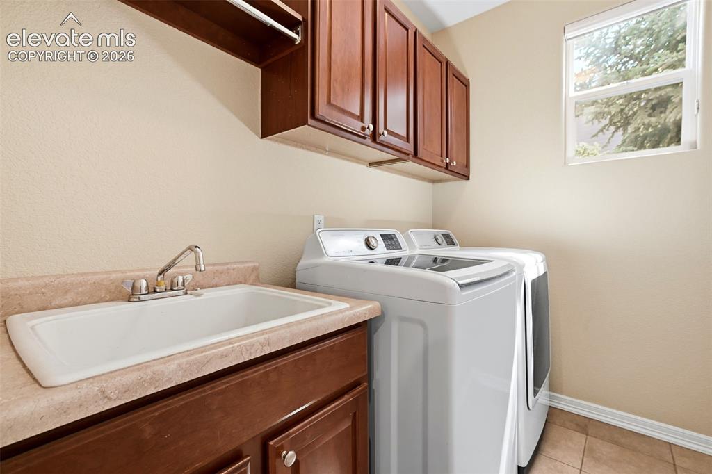 Image 34 of 50: Laundry room with utility sink and plenty of cabinet space