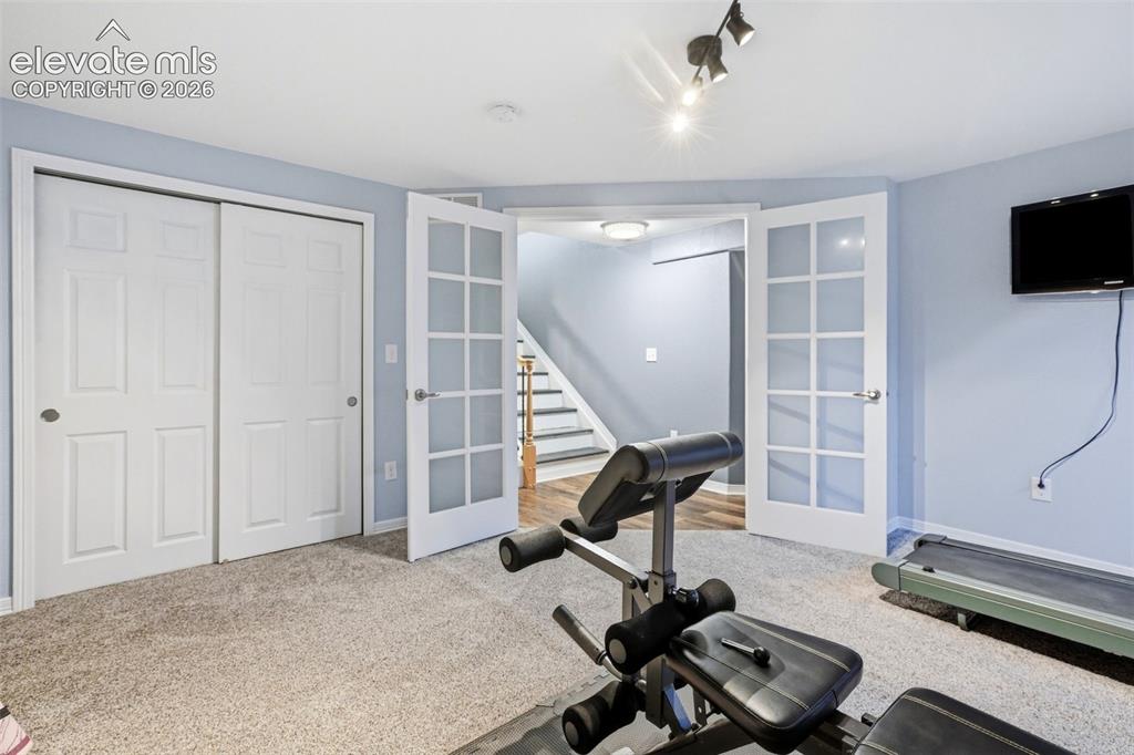 Image 47 of 50: A second bedroom with French Doors makes a great gym or office.