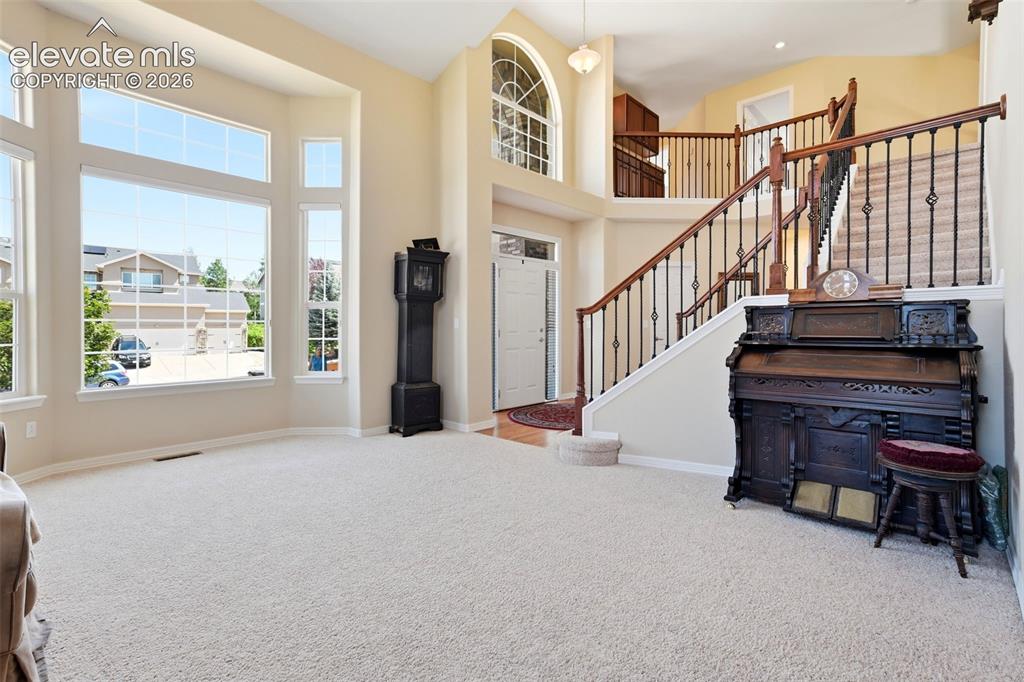 Image 6 of 50: The living room offers an open feel with high ceilings and large windows.
