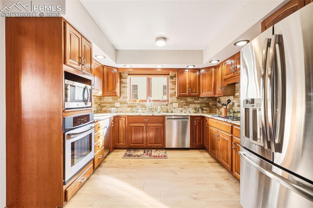 Image 11 of 50: Thoughtfully designed workspace with ample counter space, double sink benea