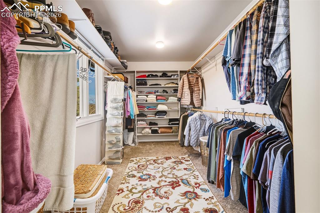 Image 21 of 50: Spacious walk-in closet with custom shelving, dual hanging rods, and natura