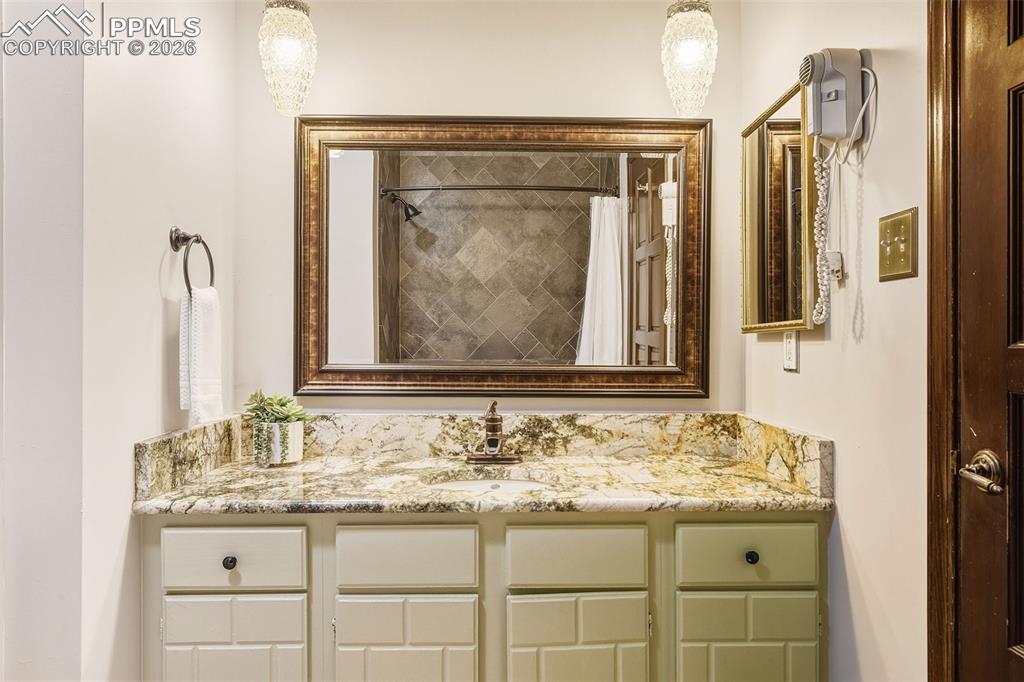 Image 24 of 50: Bathroom #2, Granite countertop, framed mirror, and updated lighting create