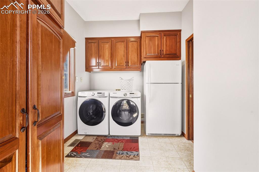Image 26 of 50: Main-level laundry with upper storage cabinetry, additional refrigerator sp