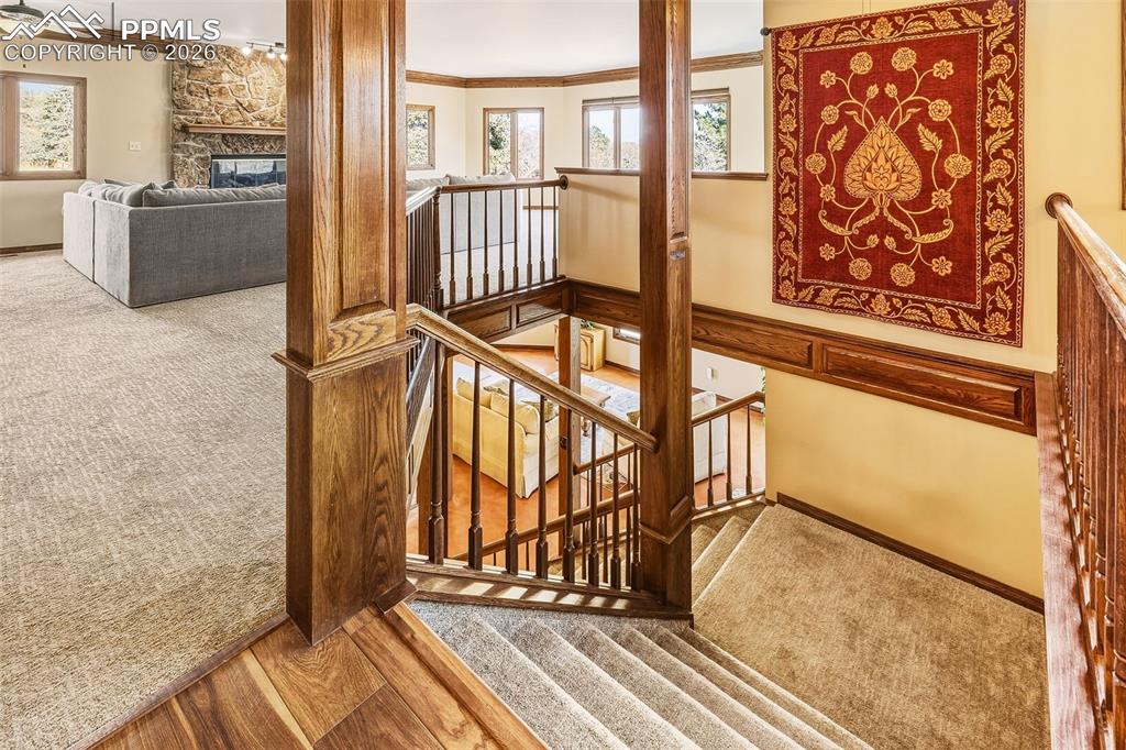 Image 28 of 50: Upper Landing & Staircase – Open stairwell with rich wood trim and railing