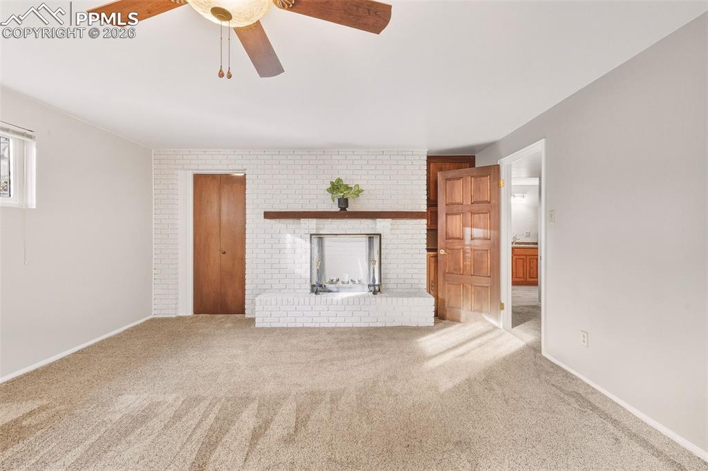 Image 32 of 50: Expansive bedroom #3 showcasing a white brick fireplace with wood mantel, g