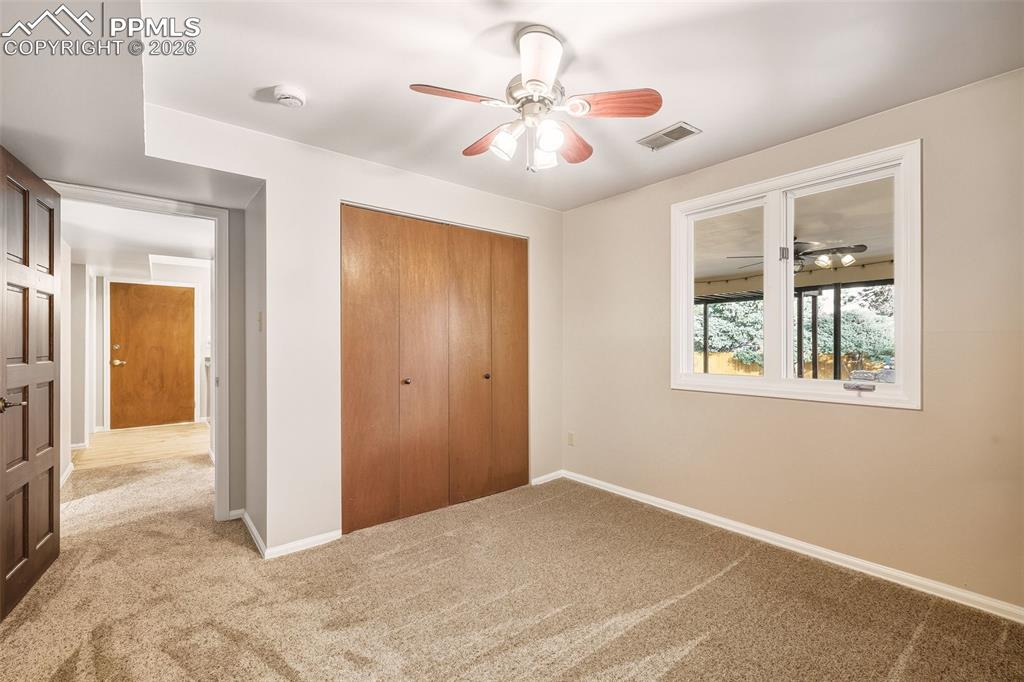 Image 34 of 50: Flexible bedroom #4 with nice carpet & Ceiling fan with above grade window.