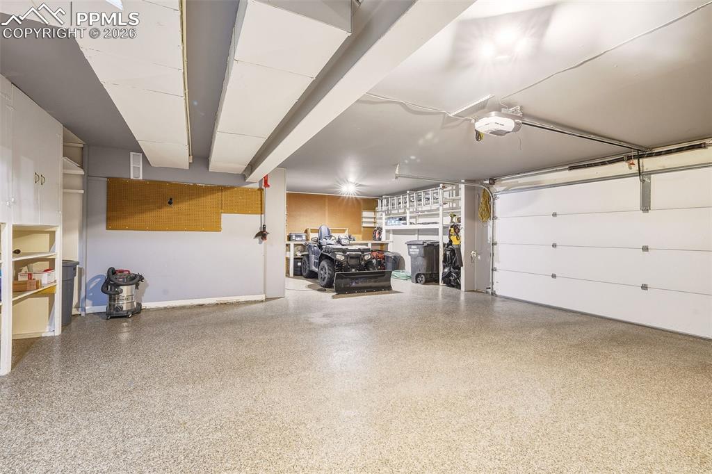 Image 36 of 50: Oversized 2+ car garage with upgraded epoxy-coated flooring, built-in stora