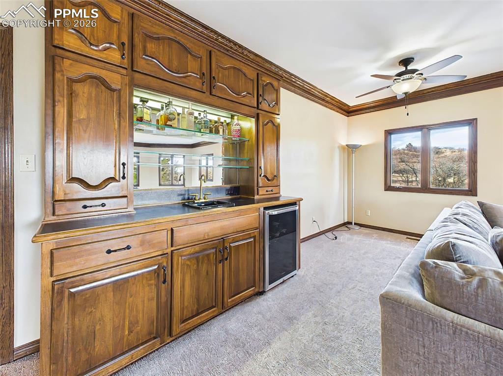 Image 7 of 50: Wet Bar – Custom built-in wet bar with glass shelving, accent lighting, sin