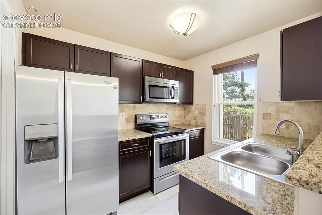 Image 11 of 31: The Kitchen features wood cabinets with countertops and stainless steel app