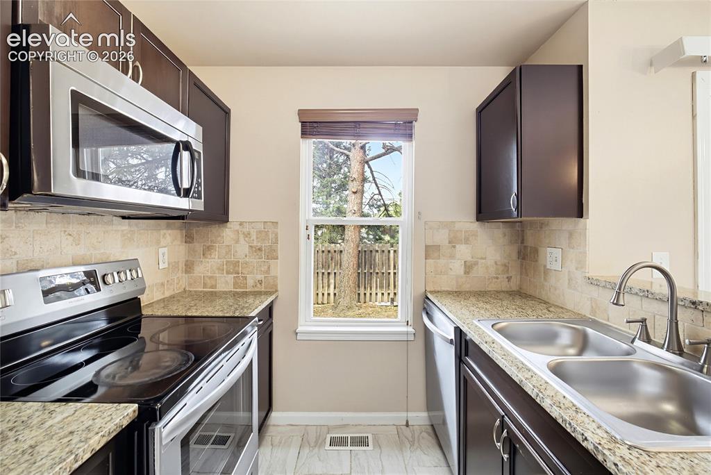 Image 13 of 31: Kitchen with double stainless steel sink and window to the backyard.