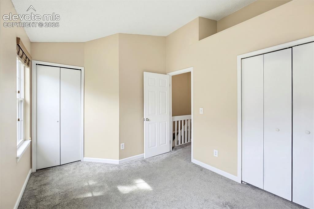 Image 17 of 31: The Upper Level Bedroom #2 has neutral carpet, and double closets.