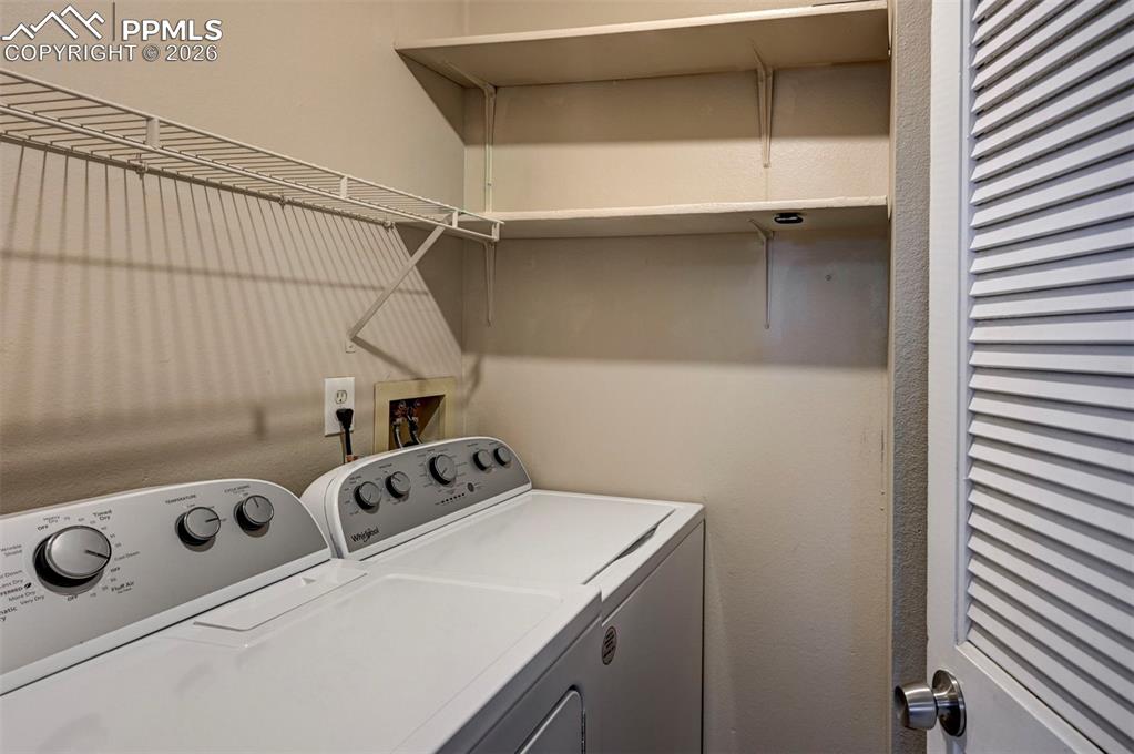 Image 19 of 31: The Laundry Room features built-in shelves and  a washer and dryer.