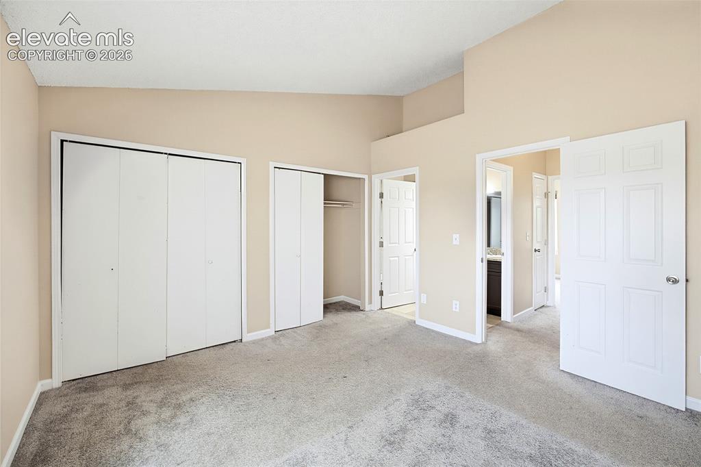 Image 19 of 31: Double closets in the Primary Bedroom and view into the adjoining Full Bath