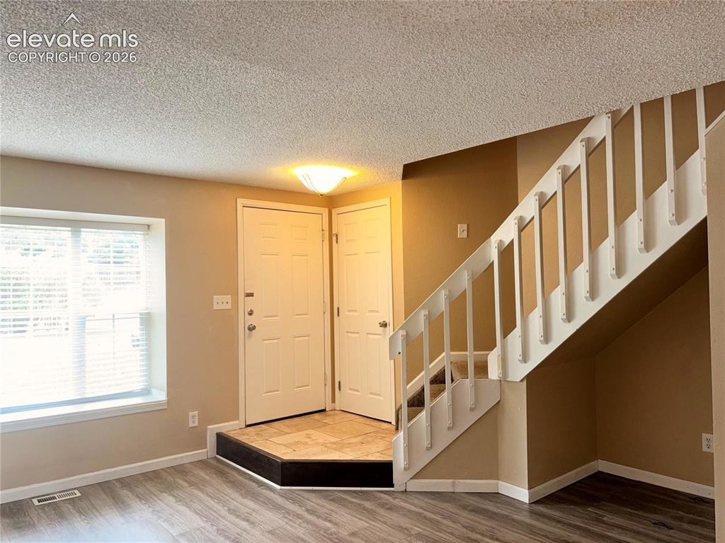 Image 2 of 31: Tiled Entry into the Living Room with stairs to the upper level.