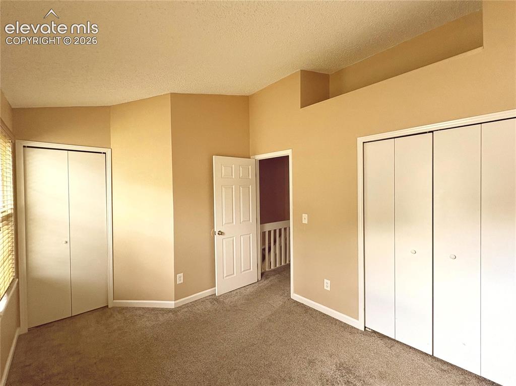 Image 22 of 31: The Upper Level Bedroom #2 has neutral carpet, and double closets.