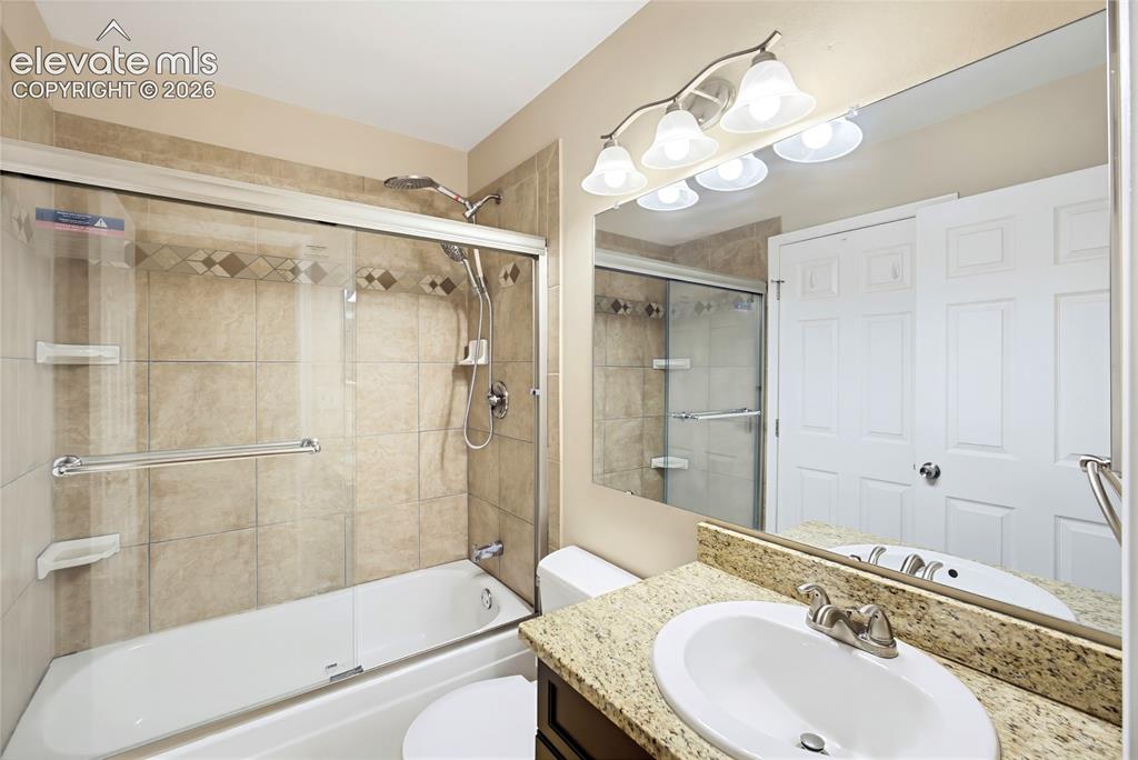 Image 22 of 31: Upper Level Bathroom includes a vanity, mirror, and tiled tub/shower