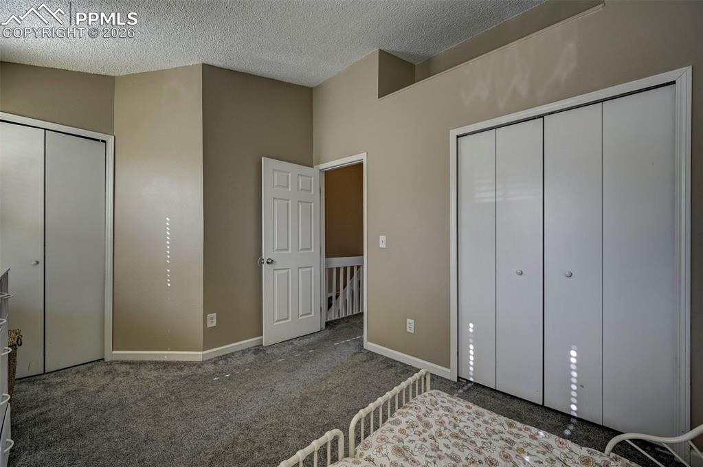 Image 26 of 31: The Upper Level Bedroom #2 has neutral carpet, and double closets.