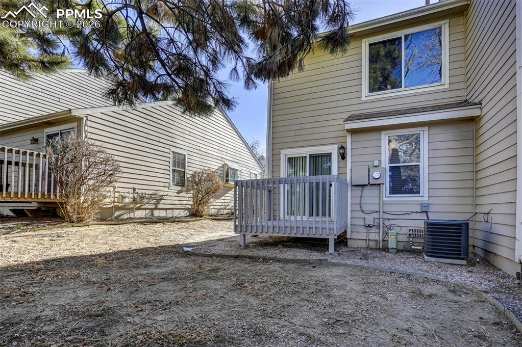 Image 29 of 31: Backyard deck and paver patio.