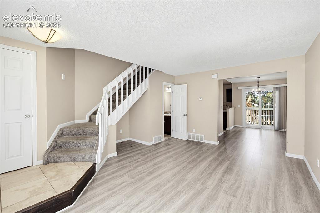 Image 3 of 31: Tiled Entry into the Living Room with stairs to the upper level.