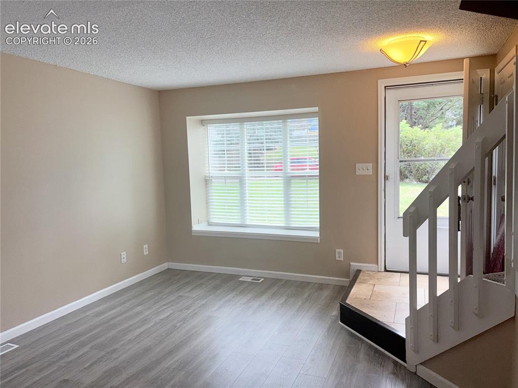Image 4 of 31: Tiled front Entry into the Living Room with stairs to the upper level.