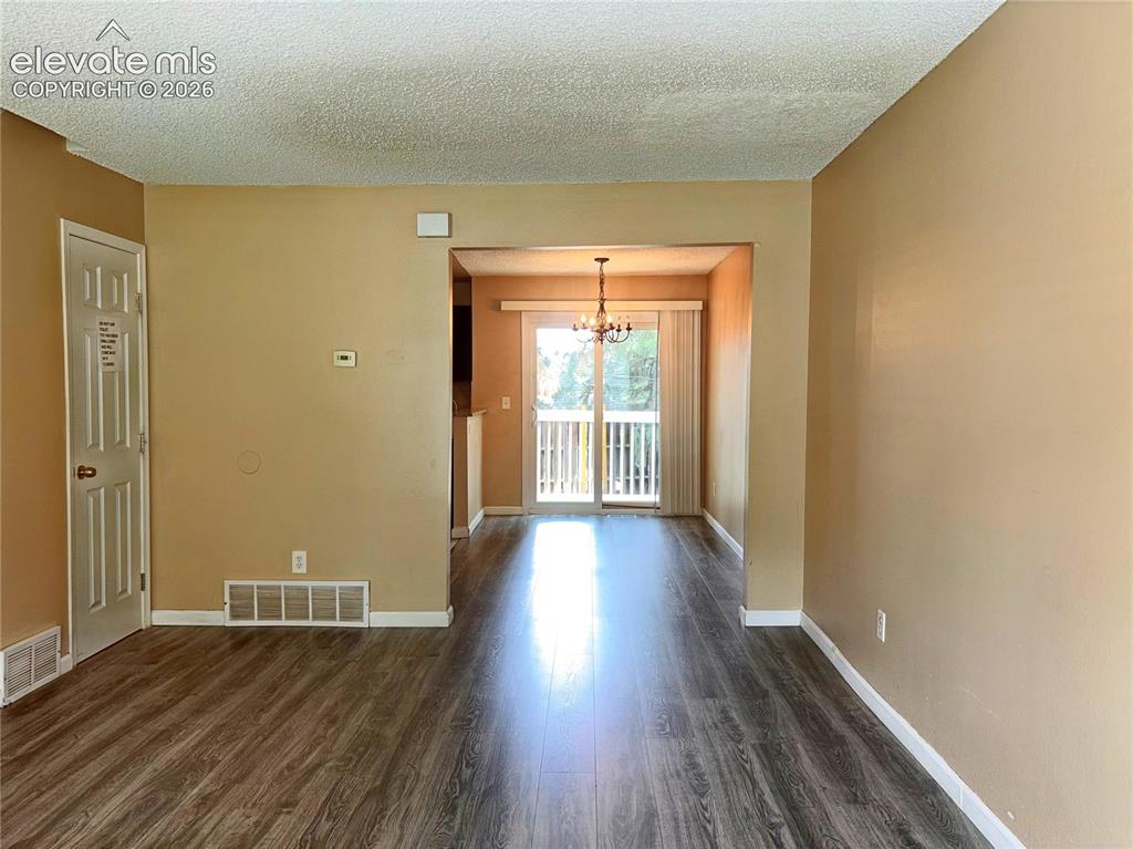 Image 7 of 31: The Living Room flows into the Dining Area and Kitchen.