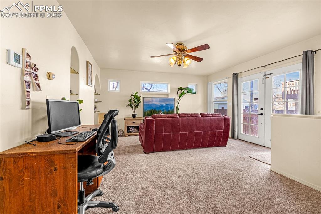 Image 17 of 38: Home office featuring light colored carpet, ceiling fan, and french doors