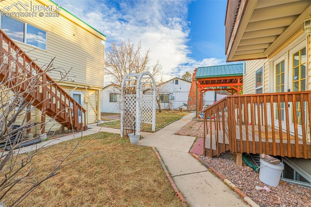 Image 36 of 38: View of grassy yard with stairway and a deck