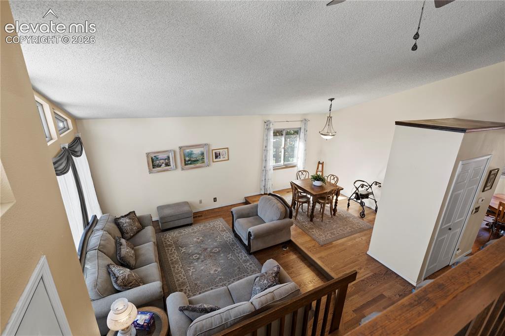 Image 14 of 43: Vaulted ceiling with textured finish, wood-finish flooring, and multiple wi
