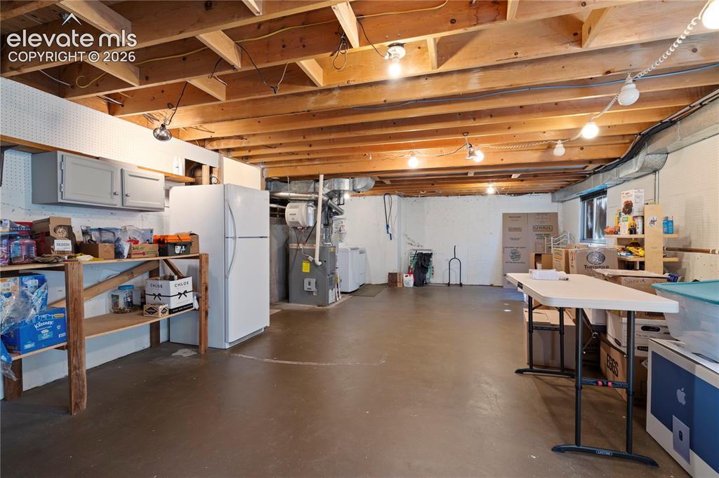 Image 32 of 43: Expansive unfinished basement featuring an exposed wood joist ceiling, conc