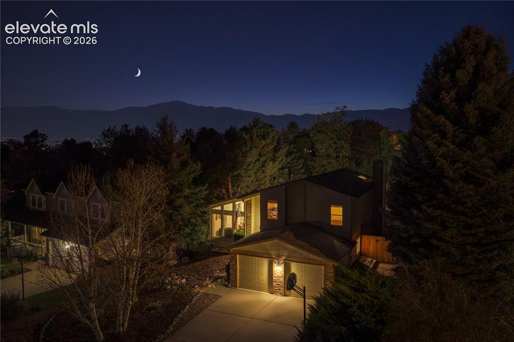 Image 37 of 43: Contemporary exterior design with an attached two-car garage, stone accents
