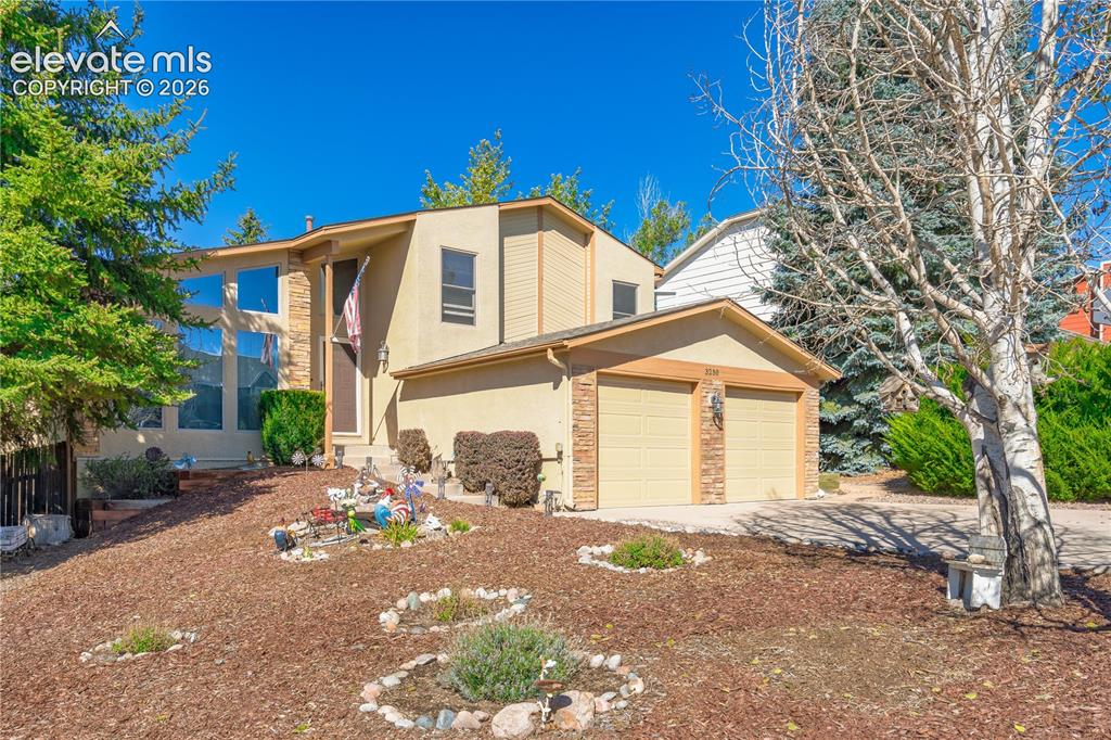 Image 40 of 43: Split-level residence featuring a two-car garage with brick veneer accents