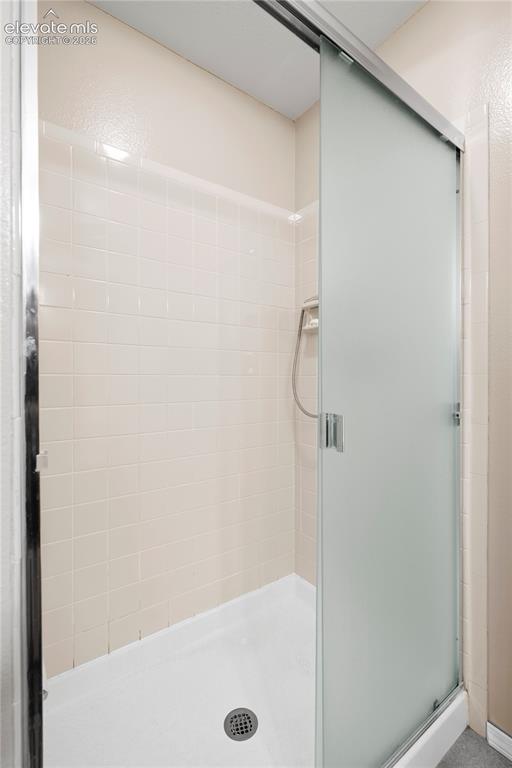 Image 43 of 43: Frosted glass shower enclosure with sliding door, featuring a tiled interio