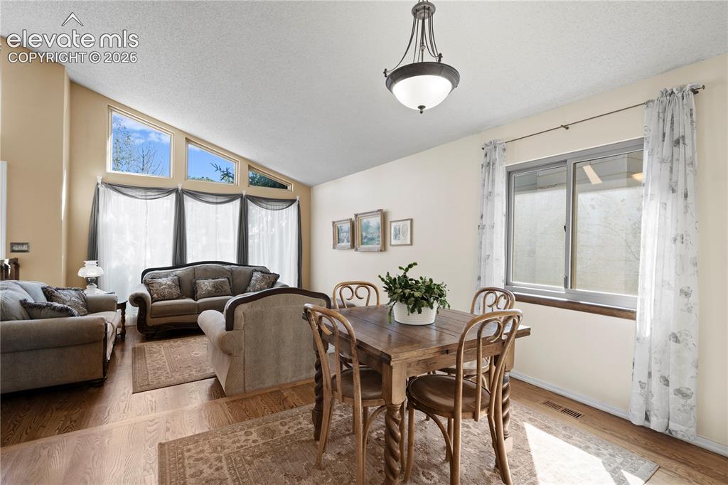 Image 6 of 43: Vaulted ceiling with high windows, wood-finish flooring, and a decorative p