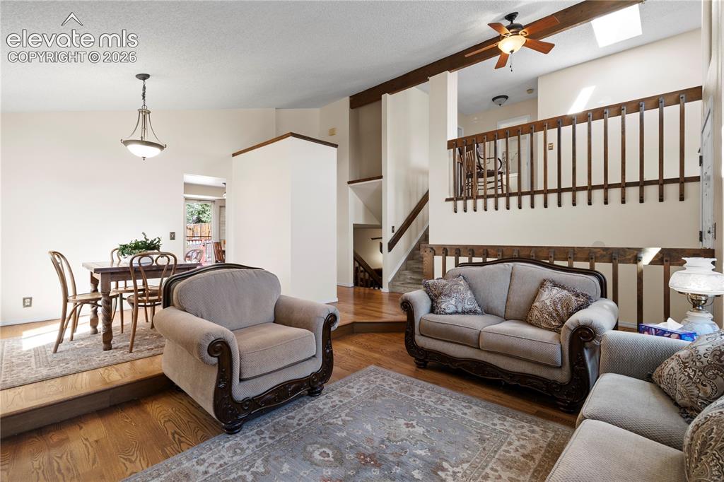Image 8 of 43: Hardwood flooring throughout, exposed wood beams, skylight, and a ceiling f