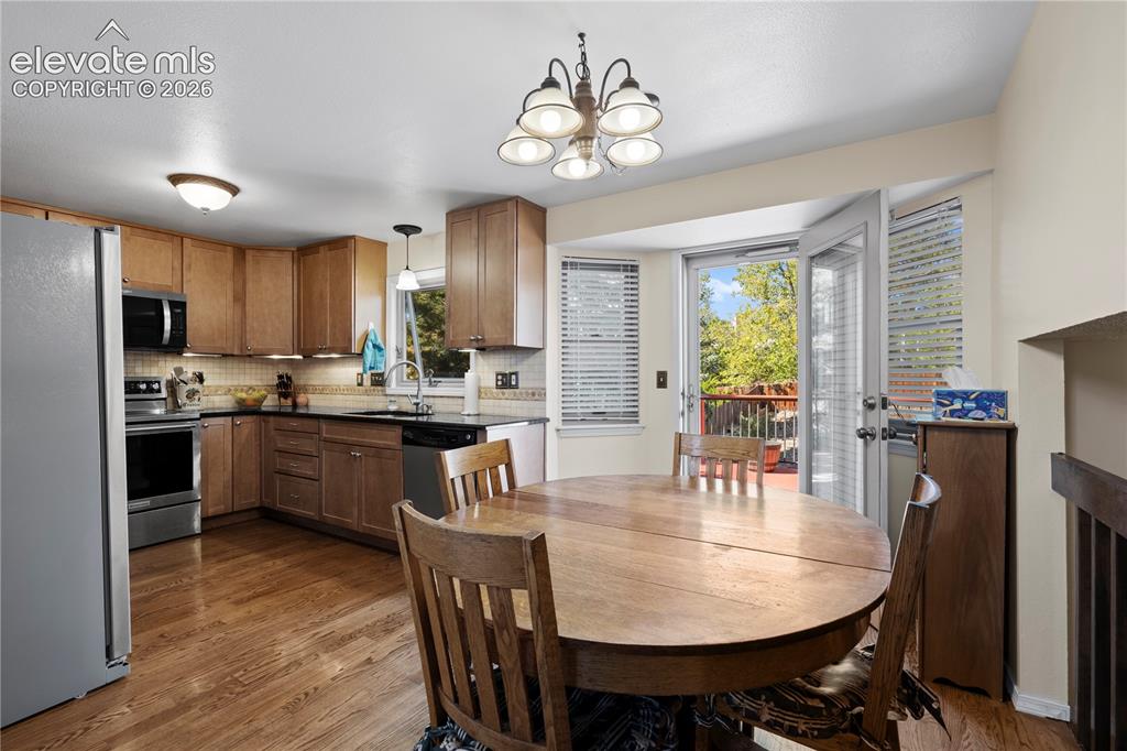 Image 9 of 43: Kitchen featuring wood-finish cabinetry, stainless steel appliances, dark c