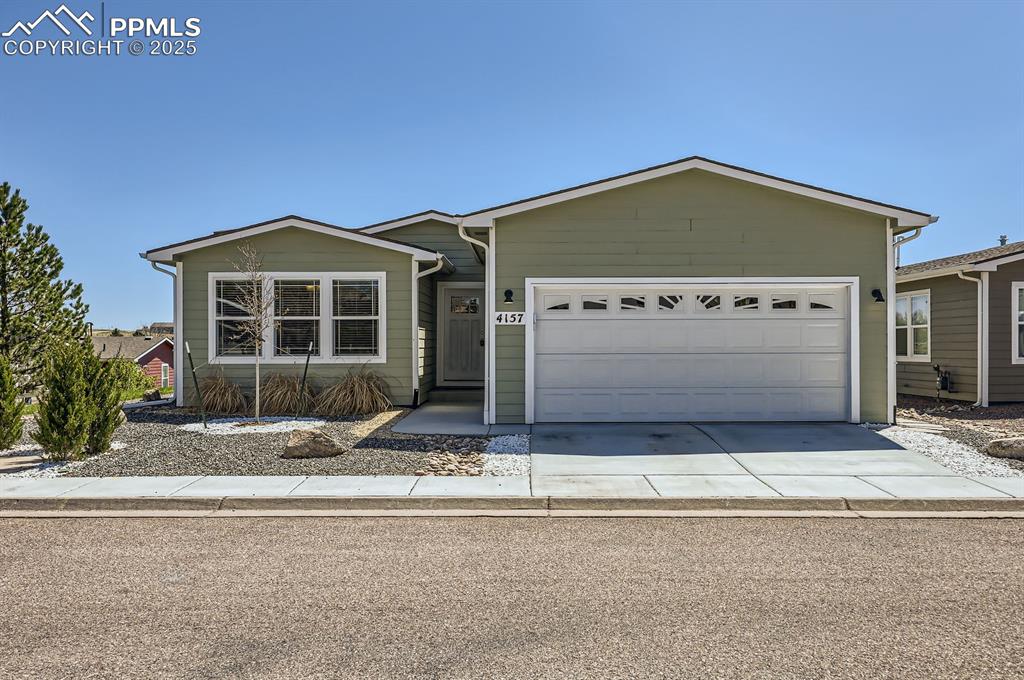 Caption: Single story home featuring an attached garage and concrete driveway