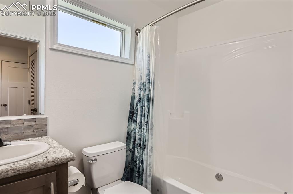 Image 21 of 28: Full bathroom featuring vanity, decorative backsplash, and shower / bath co