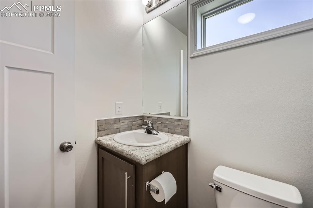 Image 25 of 28: Bathroom with tasteful backsplash and vanity