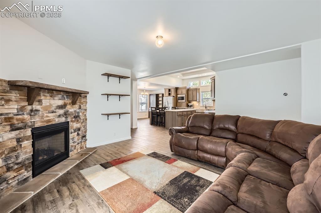 Image 7 of 28: Living room featuring light wood-type flooring and a fireplace