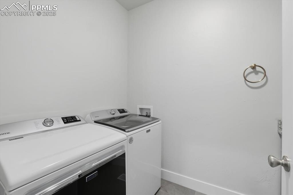 Image 30 of 49: The main-floor laundry is spacious and bright.