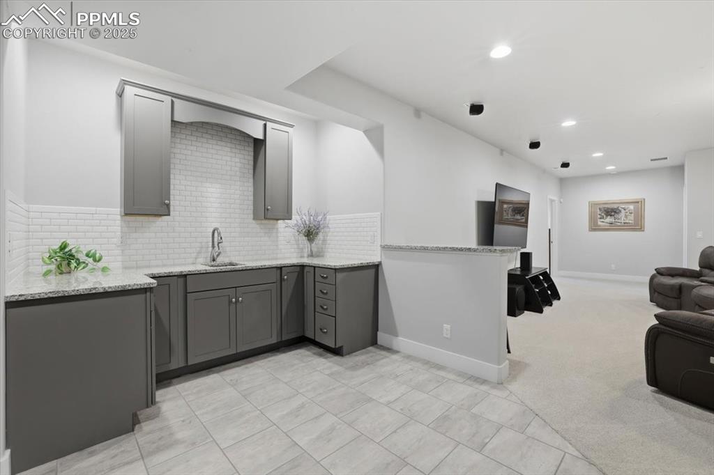 Image 40 of 49: The basement wet bar is the perfect spot to grab a snack.