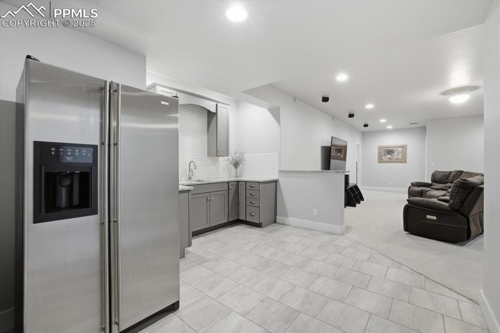 Image 41 of 49: The basement bar area includes room for a full-sized refrigerator.